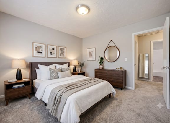 A bedroom with a large bed, nightstands, and a mirror.