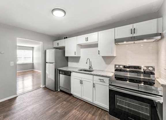 a kitchen with stainless steel appliances and white cabinets at Gardens at Washington Park, Atlanta, Georgia