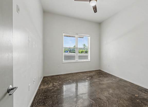 A room with a window and a ceiling fan.