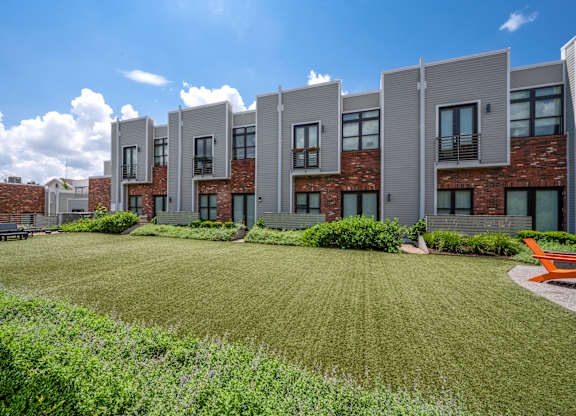 A row of modern houses with a green lawn in front.