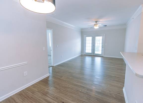 A room with a wooden floor and a ceiling fan.