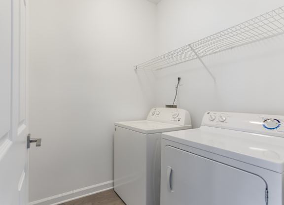 A white laundry room with a washer and dryer.