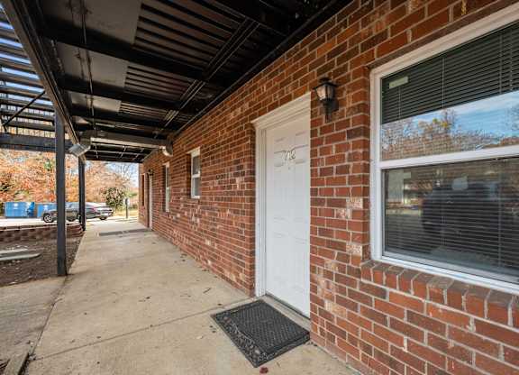 A red brick house with a white door and window.