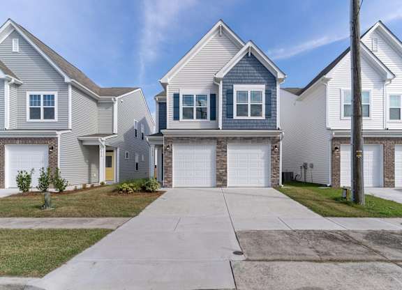 a white and blue house with white garage doors