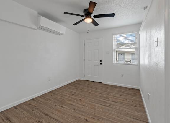the living room of our studio apartment atrium with a ceiling fan