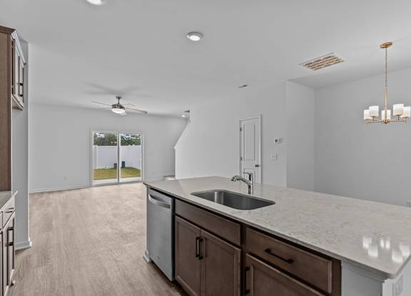 A kitchen with a marble countertop and a ceiling fan.