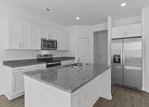 a white kitchen with granite counter tops and stainless steel appliances