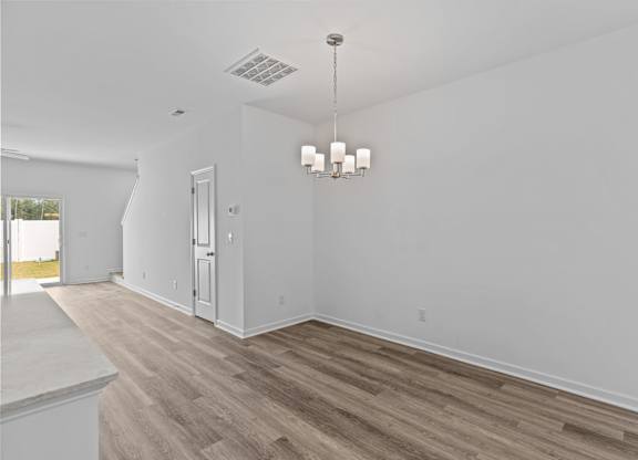 A room with a wooden floor and a chandelier.