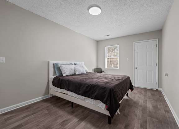 A bedroom with a bed, pillows, and a window.