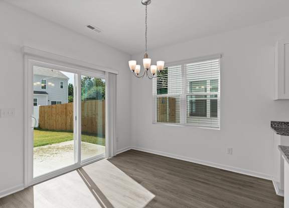 an empty living room with a sliding glass door to a yard