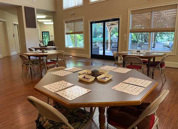 A dining room with a large table set for a game of dominoes.
