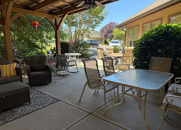 A patio with a table and chairs under a roof.