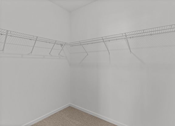 an empty closet in a white room with white walls and shelves