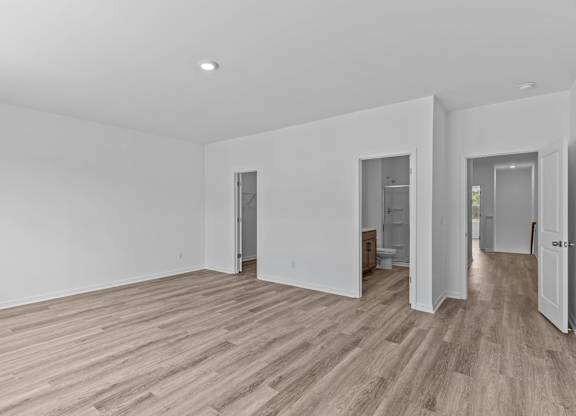 A room with wooden flooring and white walls.