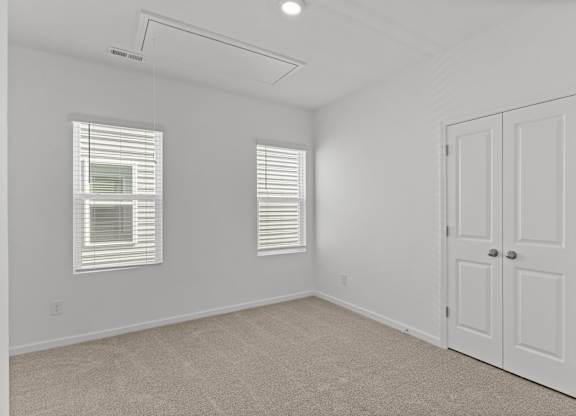 an empty bedroom with white walls and white doors and windows