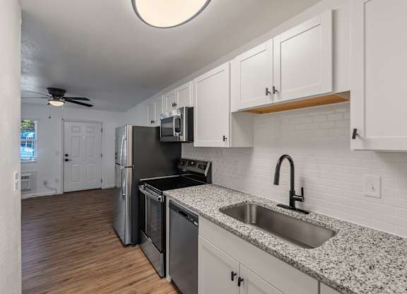 A kitchen with a sink, stove, and refrigerator.