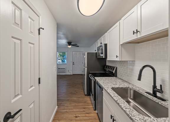 A kitchen with white cabinets and a black stove top oven.