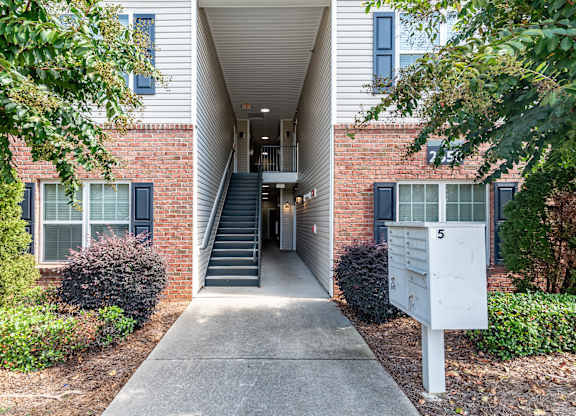 an exterior view of a brick building with stairs and a sidewalk