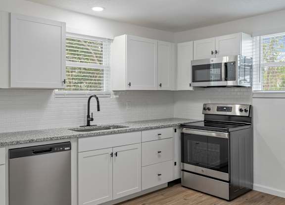 a kitchen with white cabinets and stainless steel appliances