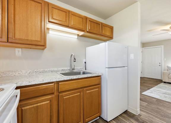 A kitchen with wooden cabinets and a white refrigerator.