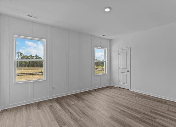 A room with a view of a field through the window.