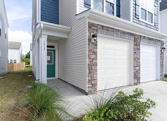 the front of a house with two white garage doors