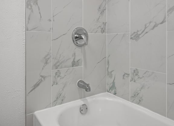 A white sink in a marble tiled bathroom.