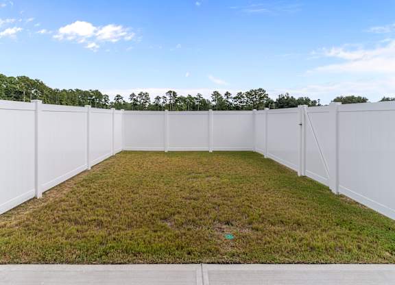 A white fenced yard with a green lawn.