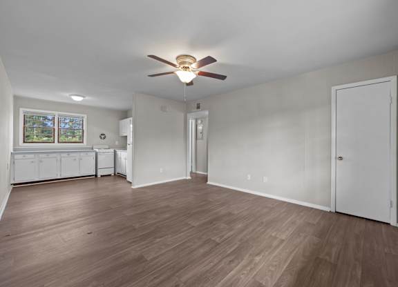 A room with a ceiling fan and wooden flooring.