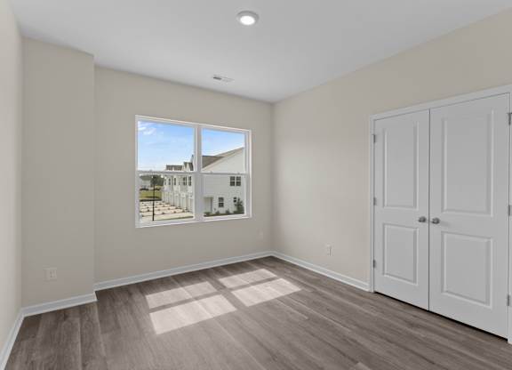 A room with a white door and a window showing a street view.