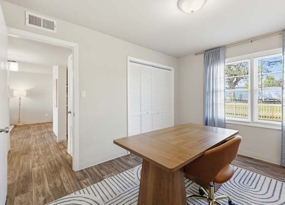 A room with a desk and chair in it.