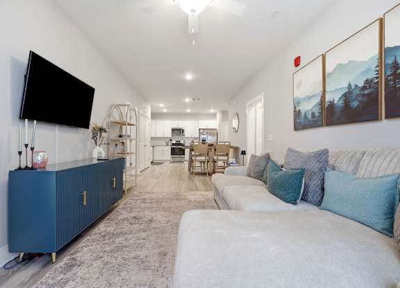 A living room with a blue cabinet and a flat screen TV mounted on the wall.