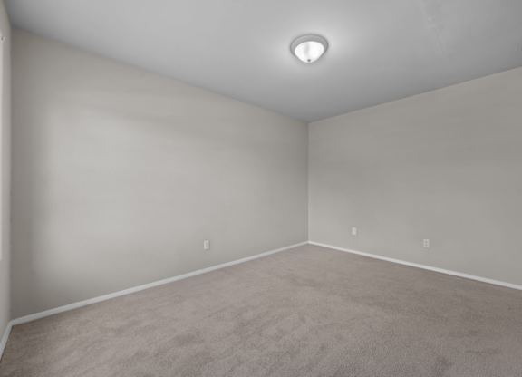 A room with a carpeted floor and a ceiling light.
