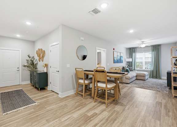 A dining room with a wooden table and chairs.