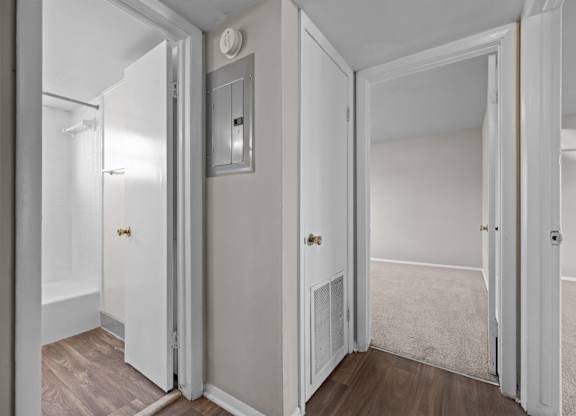 A white door is open to a room with a carpet.