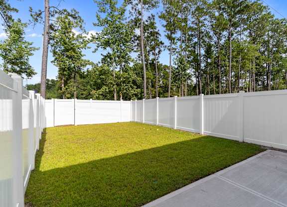 A white fence encloses a green yard.