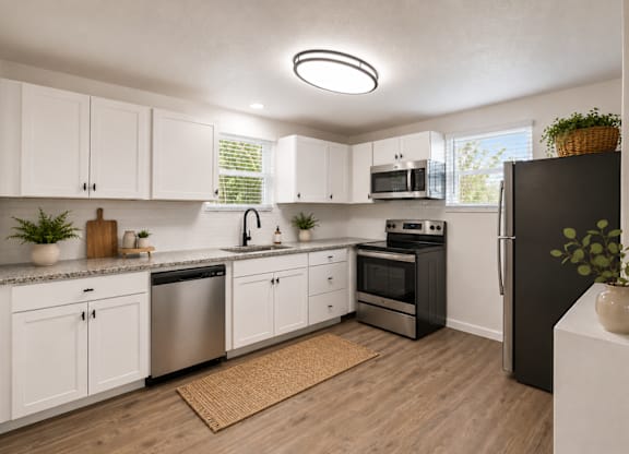 A modern kitchen with white cabinets and stainless steel appliances.