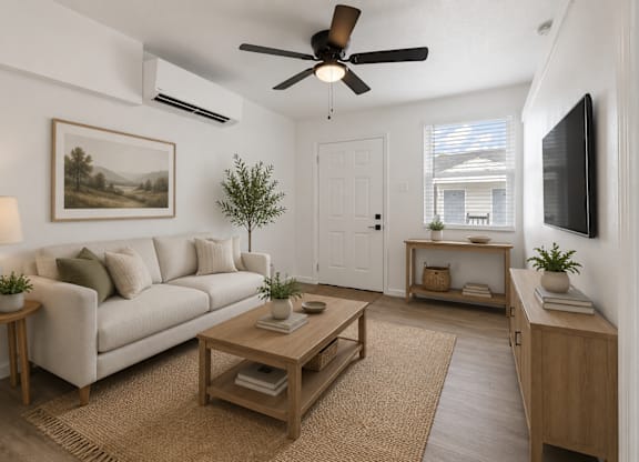 A living room with a white couch, a wooden coffee table, a ceiling fan, and a painting on the wall.