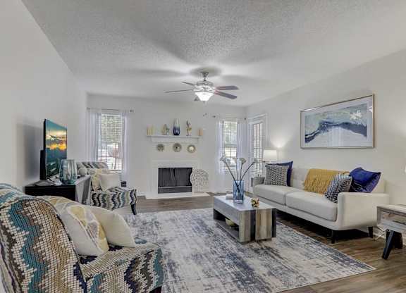 A living room with a couch, a chair, a coffee table, and a painting on the wall.