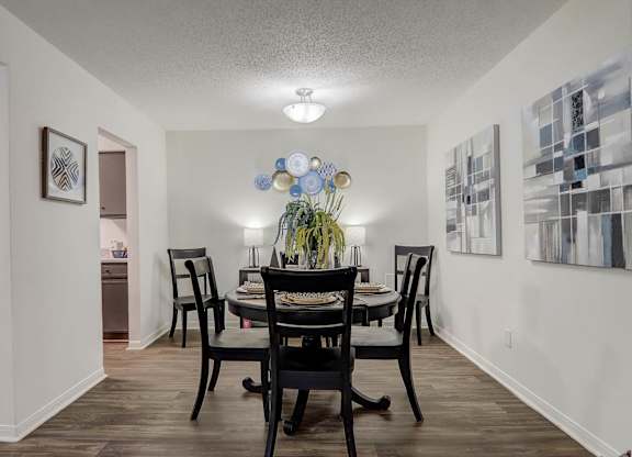 A dining room with a table set for four.