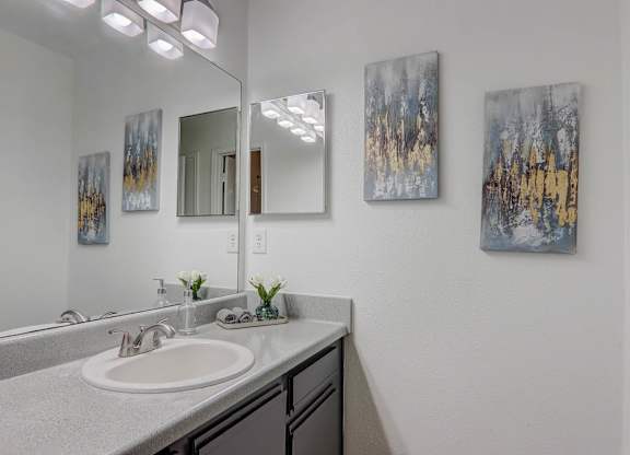 A bathroom with a sink and a mirror.