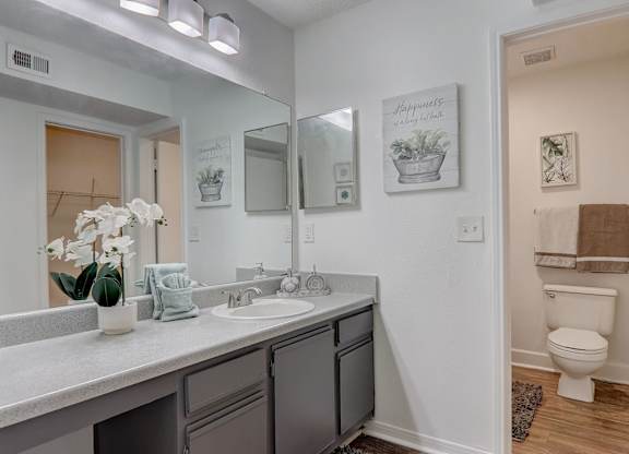 A bathroom with a white sink and a toilet.