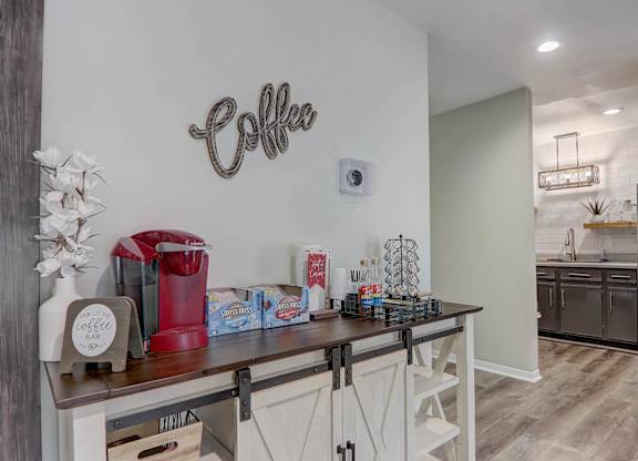 A coffee bar area with a coffee machine and a coffee sign on the wall.