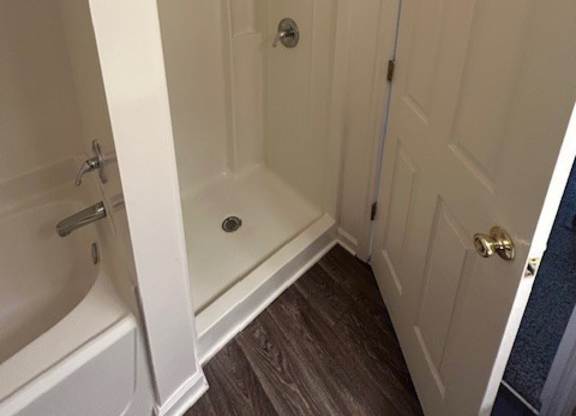 A white bathroom with a door and a shower.