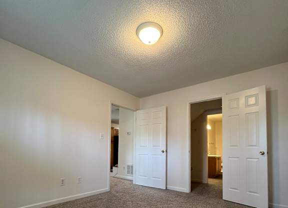 A room with a carpeted floor and a ceiling light.