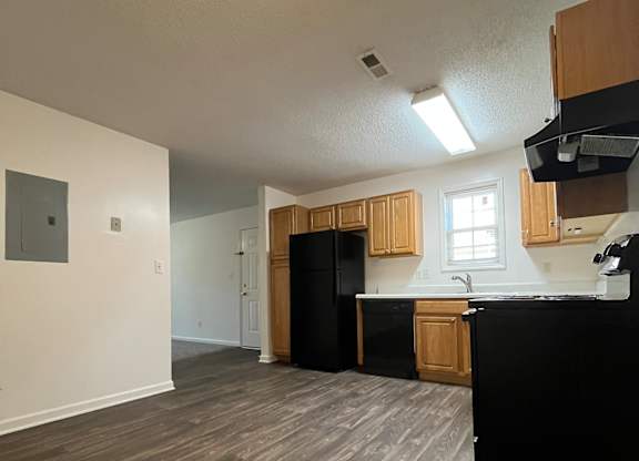 A kitchen with black appliances and wooden cabinets.