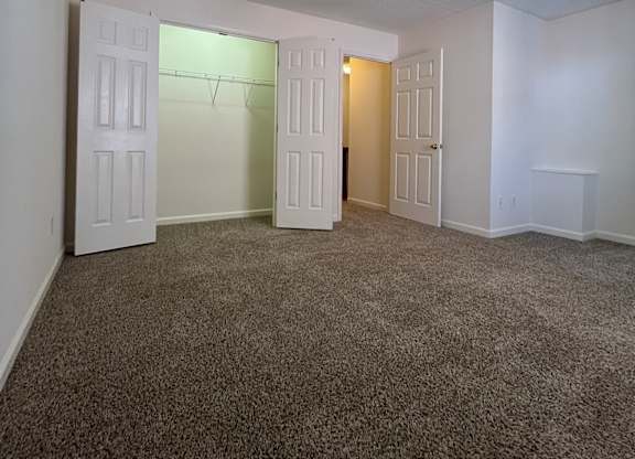 A room with a ceiling fan and carpeted floor.