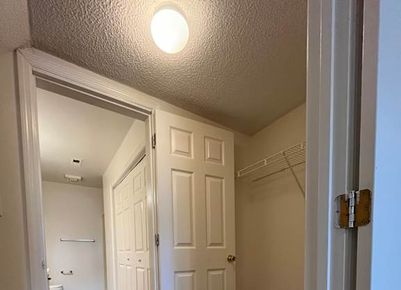 A hallway with a carpeted floor and white walls.