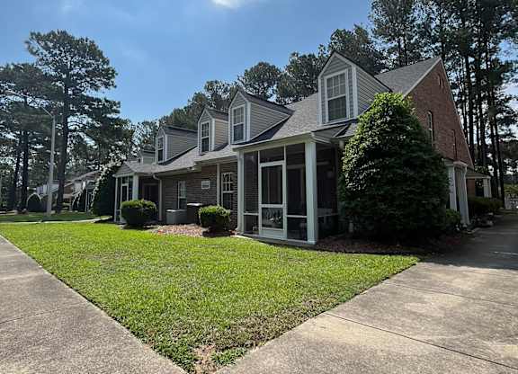 A house with a large front yard and a driveway.