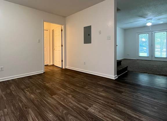 A room with wood flooring and white walls.
